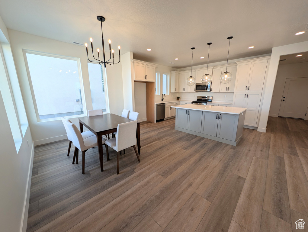 Dining area featuring a notable chandelier, hardwood / wood-style flooring, and sink