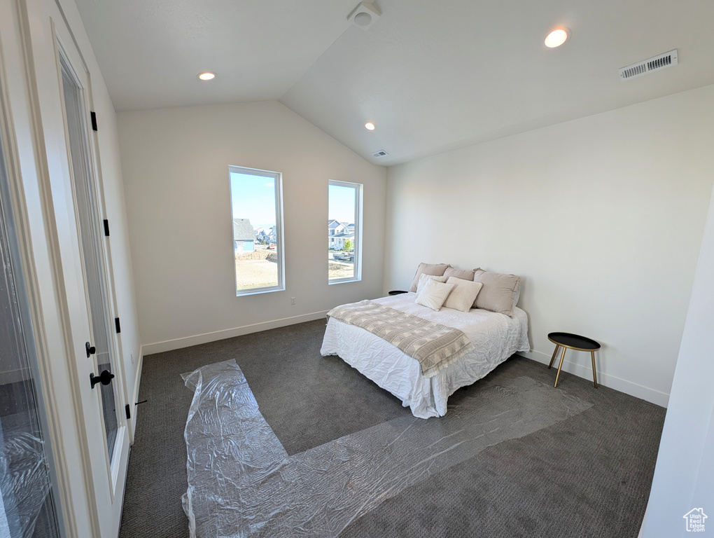 Carpeted bedroom featuring lofted ceiling