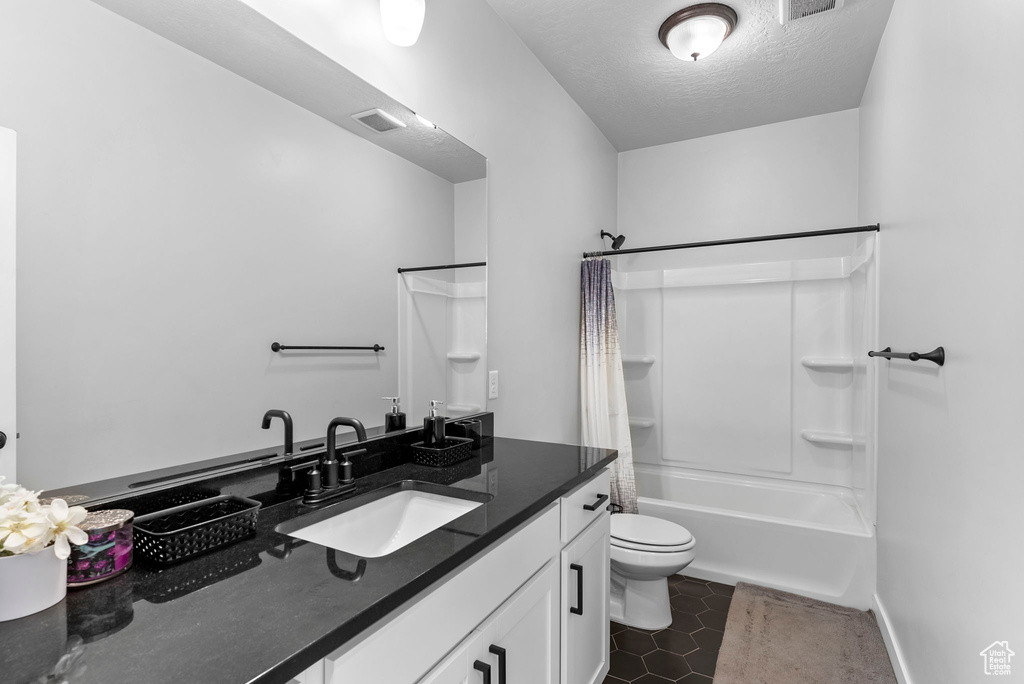 Full bathroom featuring shower / bath combo, toilet, tile patterned floors, and vanity