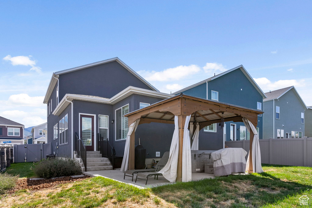 Rear view of house with a patio and a yard