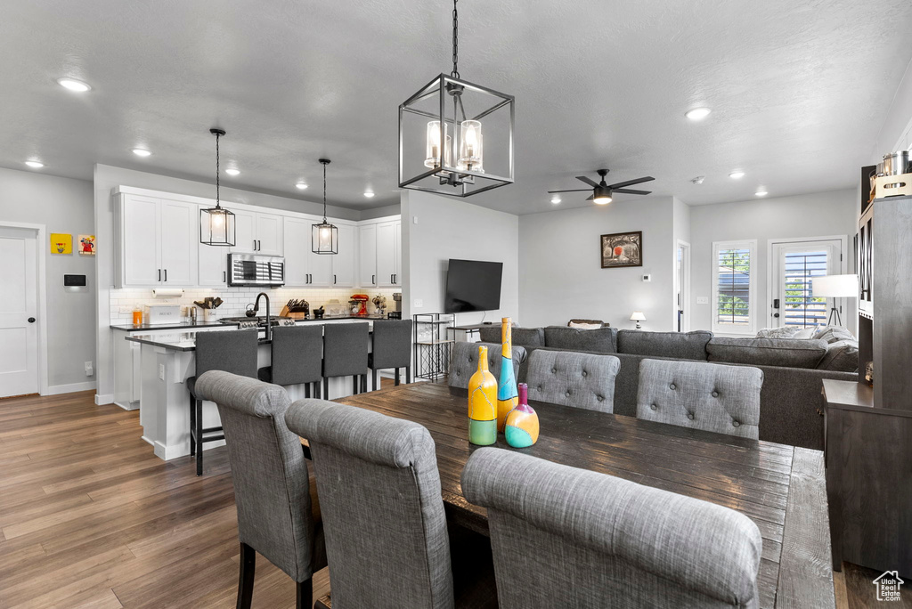 Dining room featuring dark hardwood / wood-style floors and ceiling fan with notable chandelier