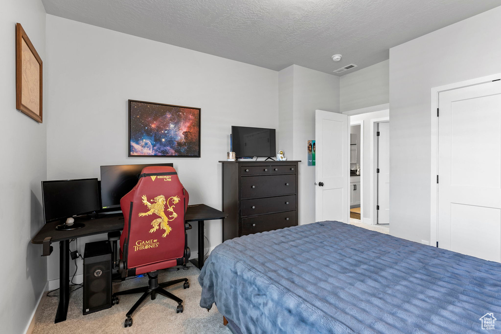 Carpeted bedroom featuring a textured ceiling