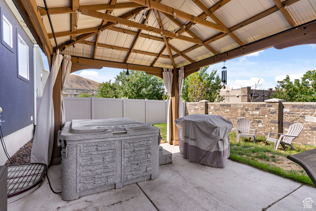 View of patio with area for grilling, a mountain view, and a gazebo