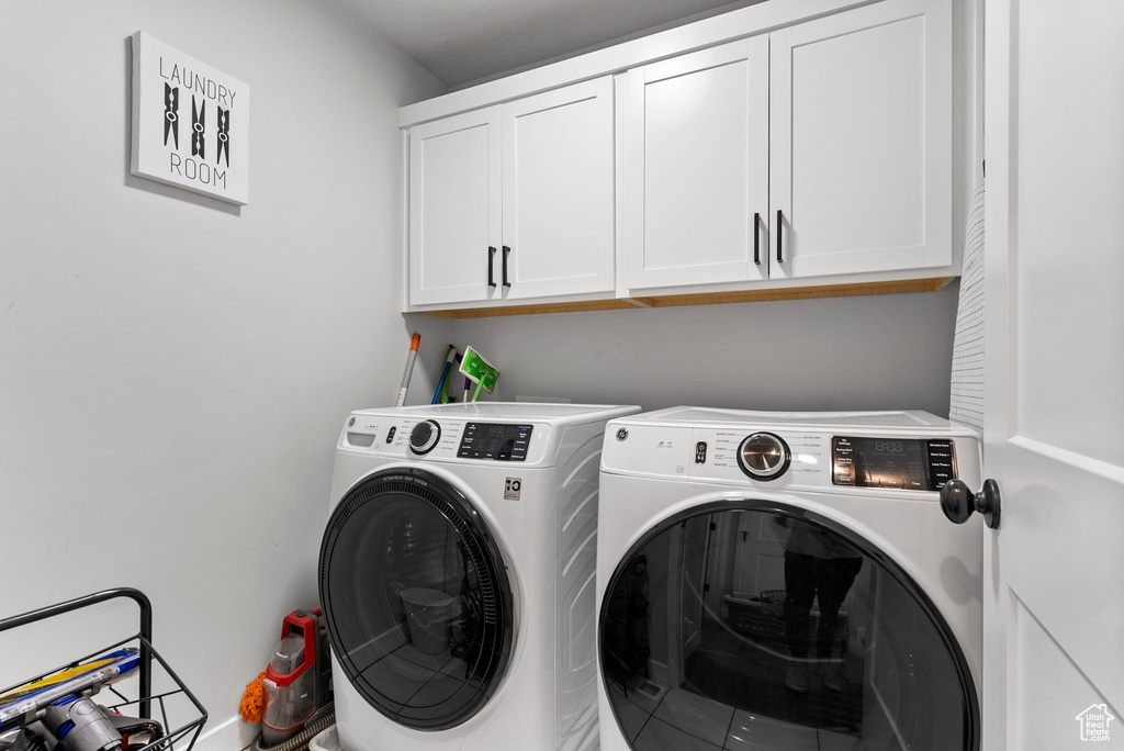 Laundry room featuring cabinets and separate washer and dryer