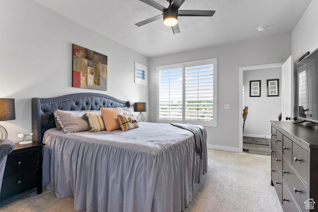 Carpeted bedroom featuring ceiling fan