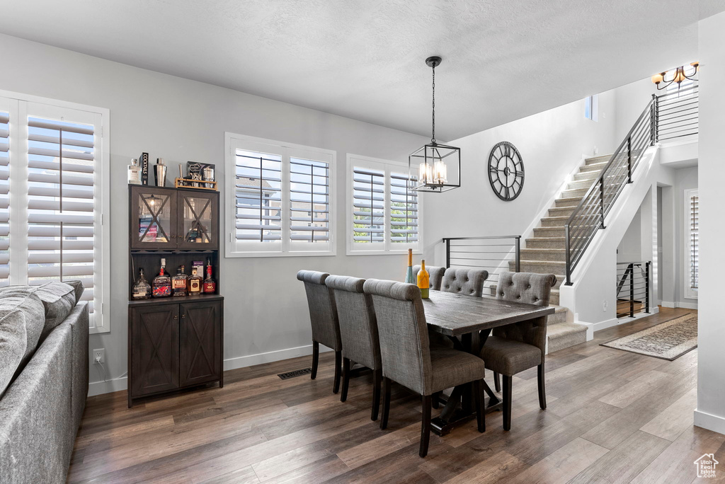 Dining area featuring wood-type flooring and a chandelier