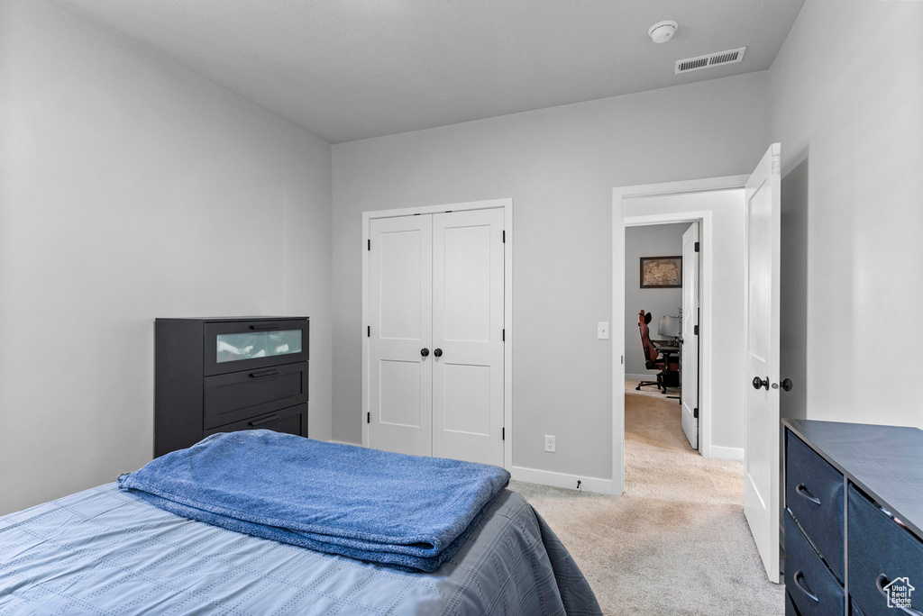 Carpeted bedroom with a closet