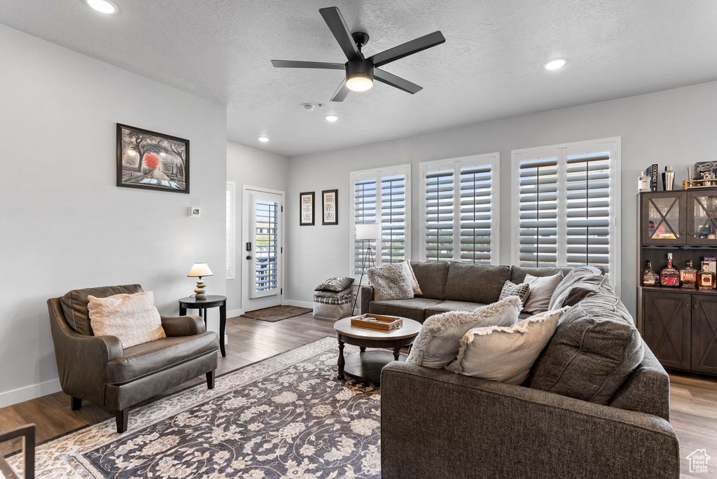 Living room with ceiling fan and light wood-type flooring