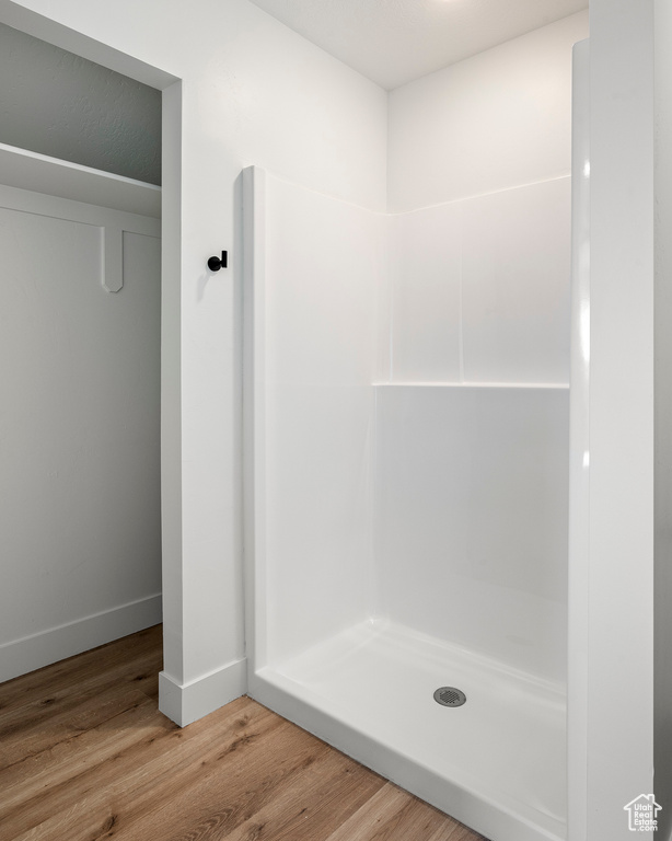 Bathroom with hardwood / wood-style flooring and walk in shower