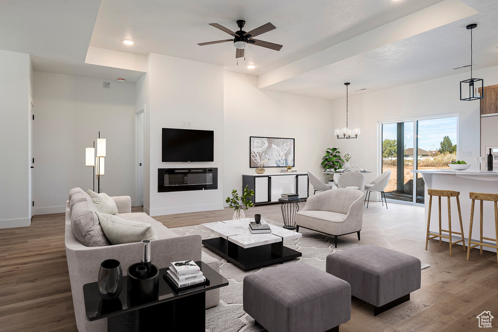 Living room featuring hardwood / wood-style floors and ceiling fan with notable chandelier