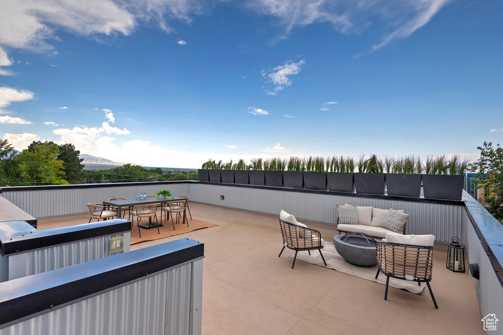 View of patio with an outdoor living space with a fire pit