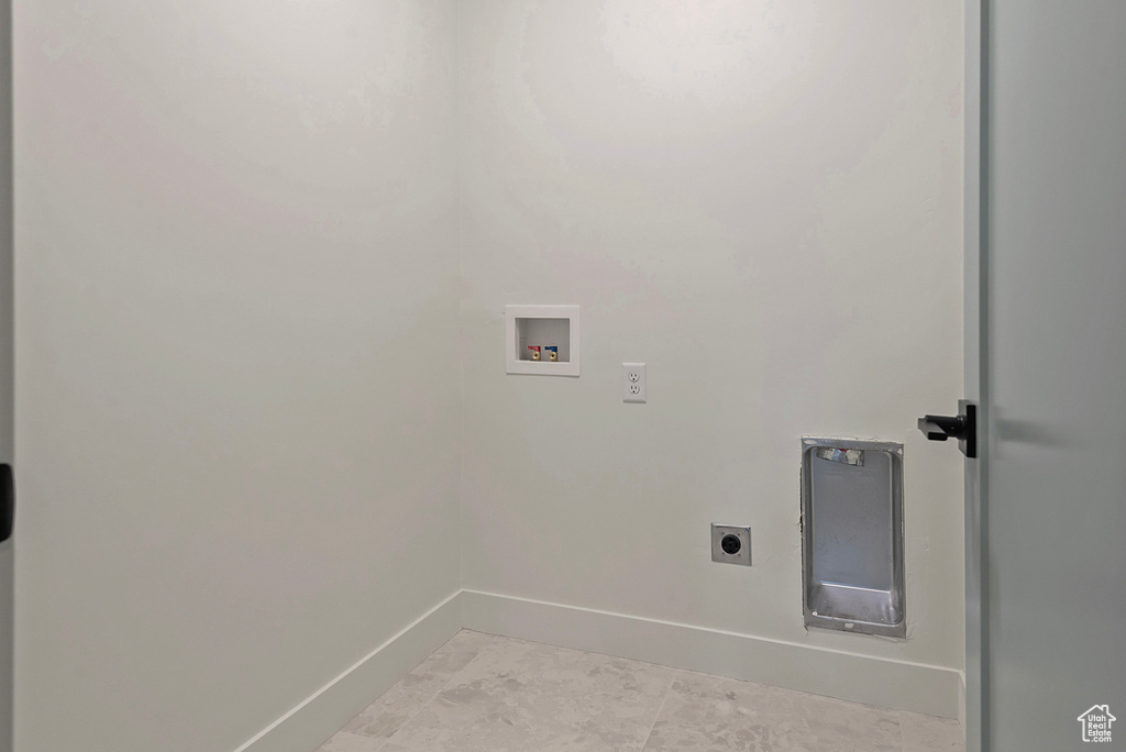 Laundry room with electric dryer hookup, hookup for a washing machine, and light tile patterned floors