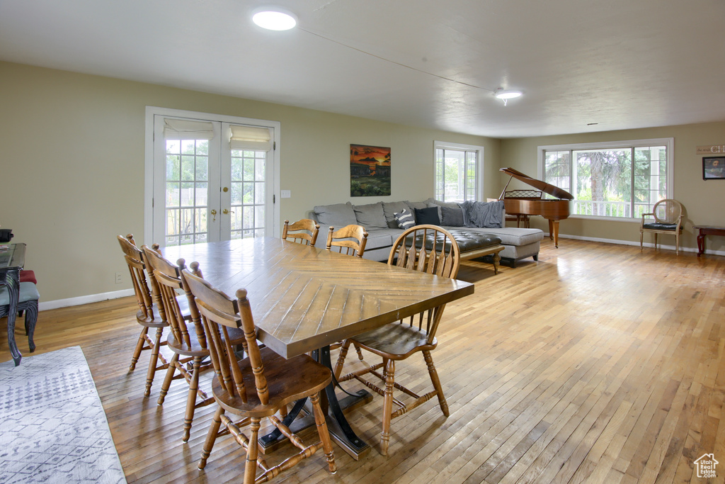 Dining area with light hardwood / wood-style flooring and french doors