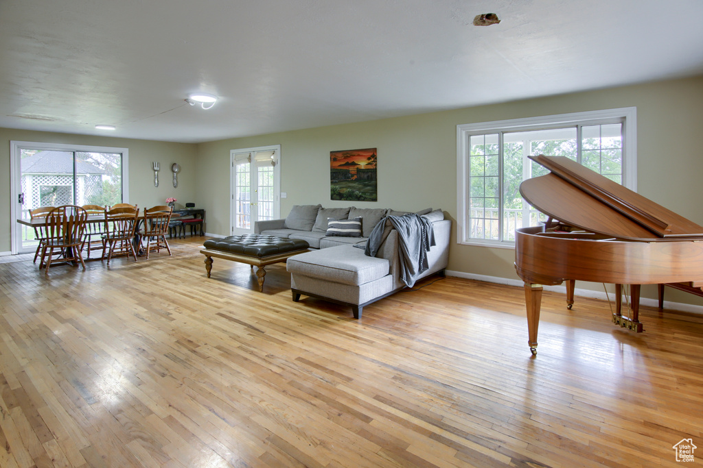 Living room with french doors and light hardwood / wood-style flooring