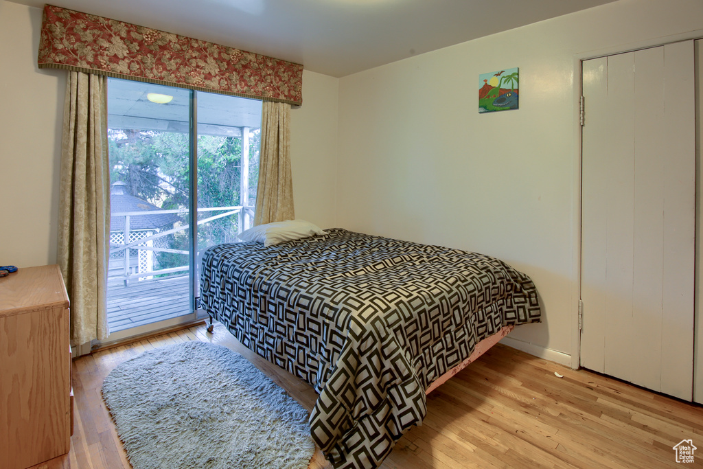 Bedroom featuring light wood-type flooring, access to outside, and a closet