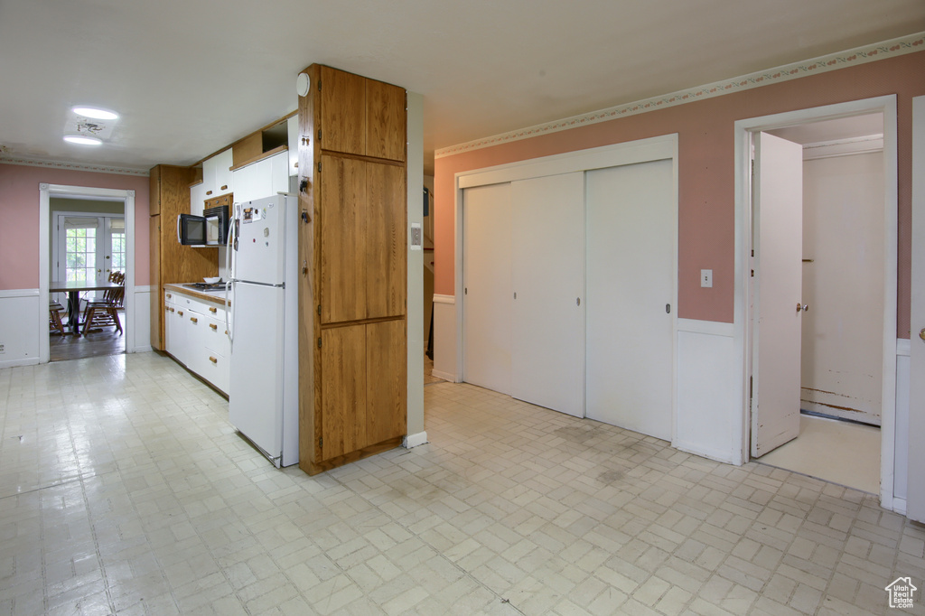 Kitchen featuring light tile patterned floors, gas cooktop, and white fridge