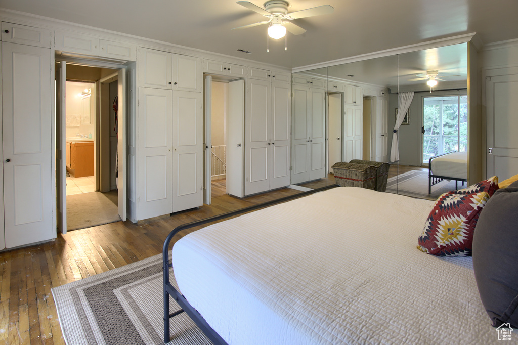 Bedroom with connected bathroom, ceiling fan, hardwood / wood-style floors, and crown molding