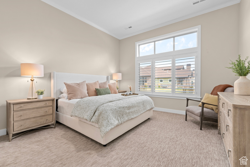 Carpeted bedroom featuring crown molding