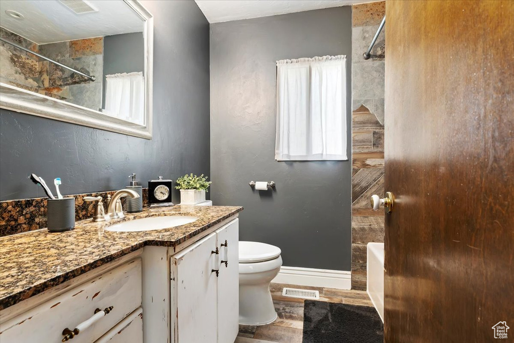 Full bathroom featuring toilet, tiled shower / bath combo, and vanity