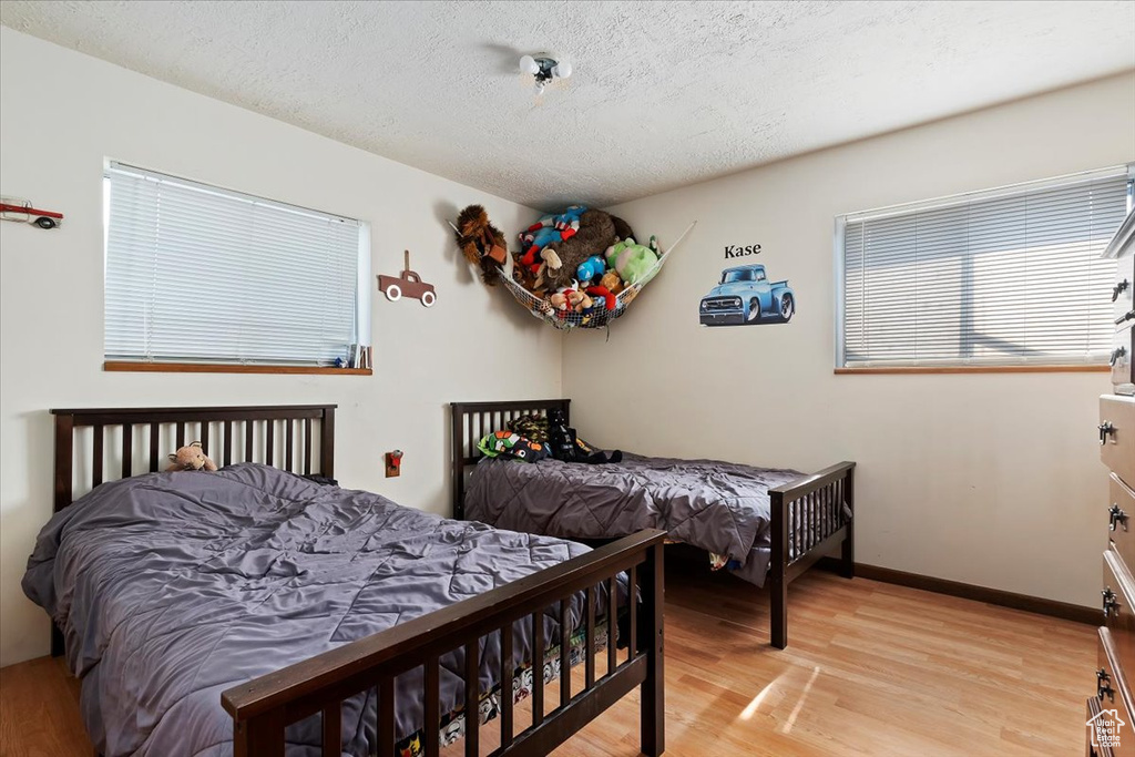 Bedroom with light hardwood / wood-style flooring and a textured ceiling