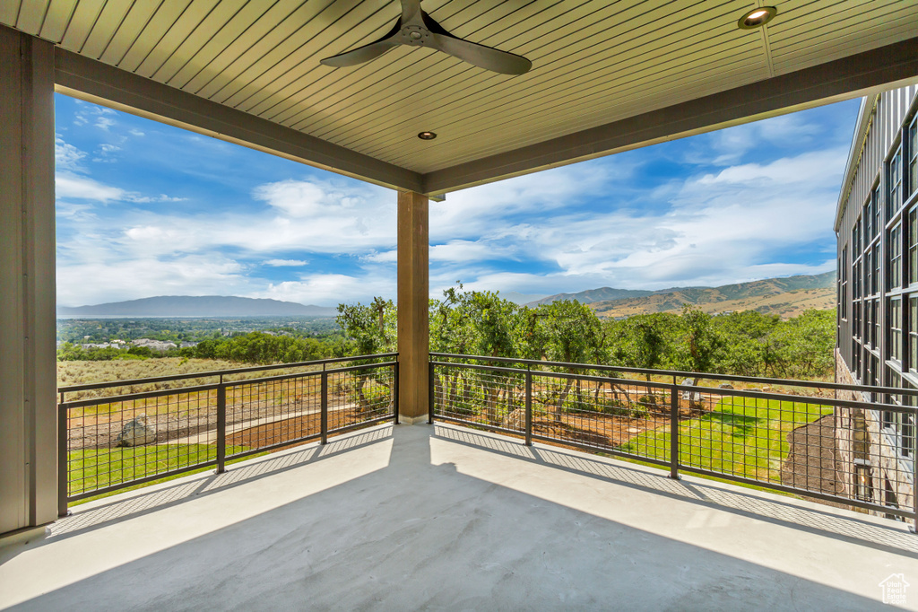 View of patio / terrace featuring a mountain view, ceiling fan, and a balcony