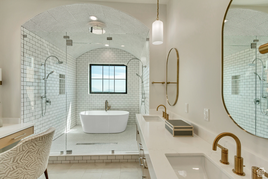 Bathroom featuring dual vanity, tile walls, tile patterned flooring, and a shower with shower door