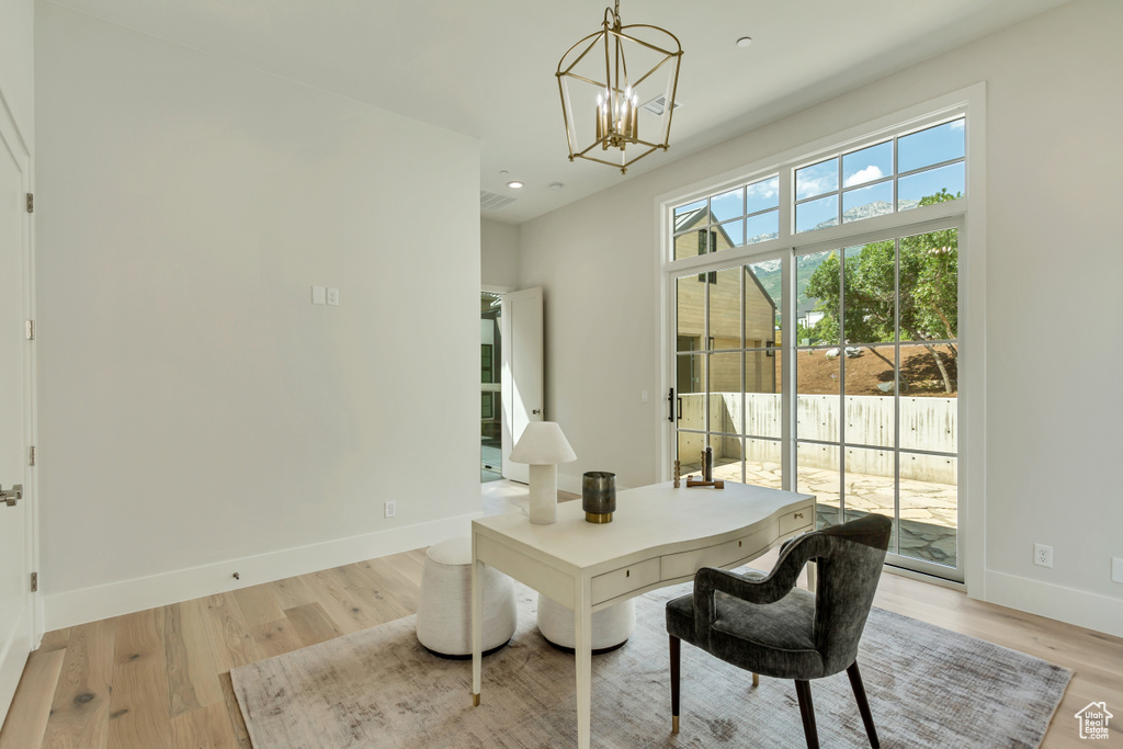 Office with a notable chandelier and light hardwood / wood-style floors