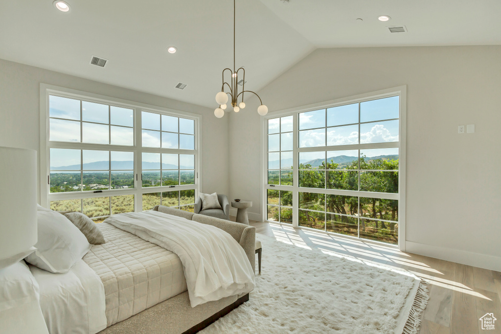 Bedroom with a notable chandelier, lofted ceiling, and hardwood / wood-style flooring