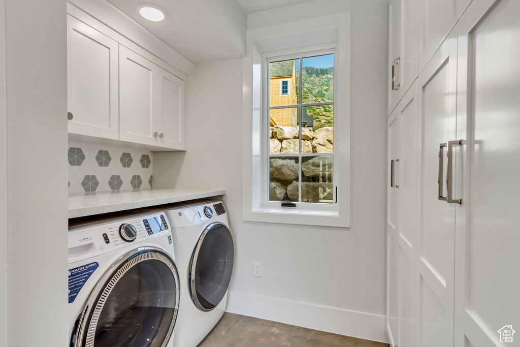 Clothes washing area with cabinets and separate washer and dryer