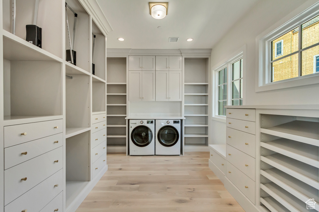 Spacious closet featuring light hardwood / wood-style flooring and washer and clothes dryer