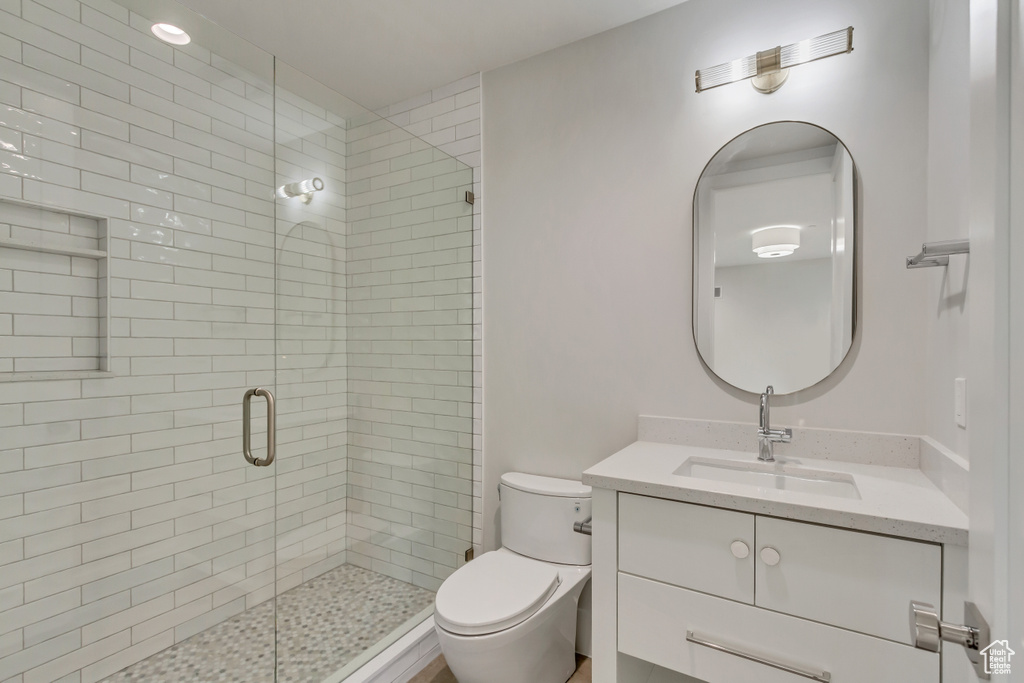 Bathroom with a shower with door, toilet, and vanity