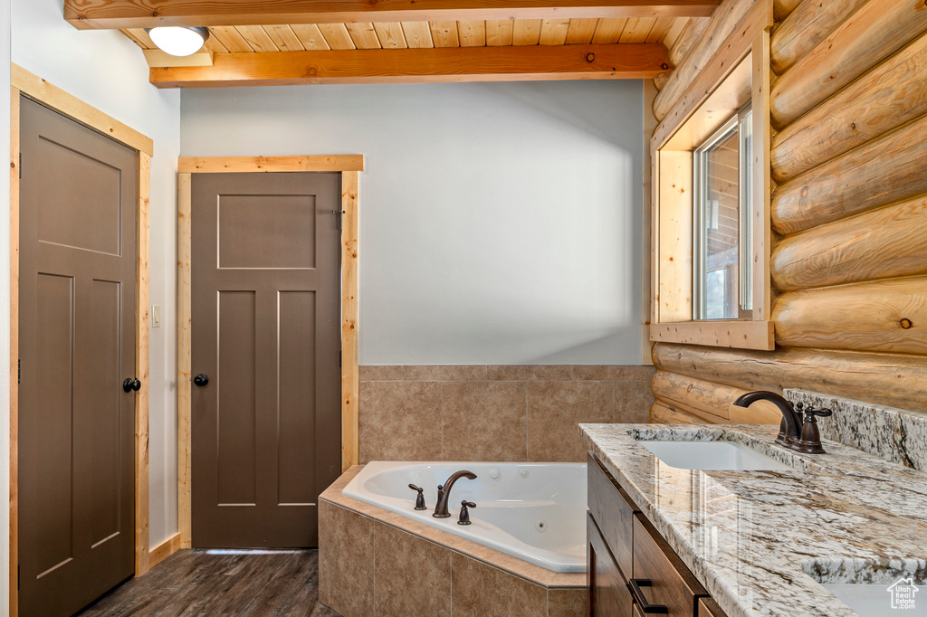 Bathroom with beam ceiling, log walls, hardwood / wood-style floors, and wood ceiling