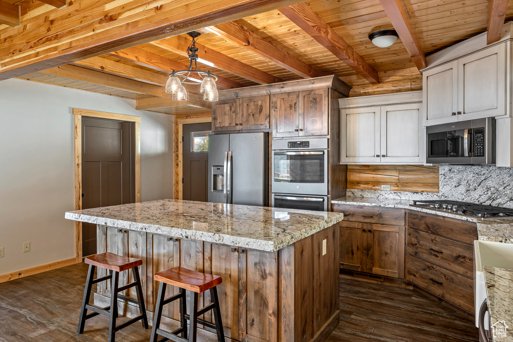 Kitchen featuring dark hardwood / wood-style floors, stainless steel appliances, hanging light fixtures, and wood ceiling