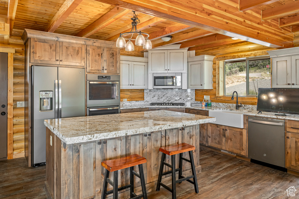 Kitchen featuring beam ceiling, wooden ceiling, stainless steel appliances, and a center island