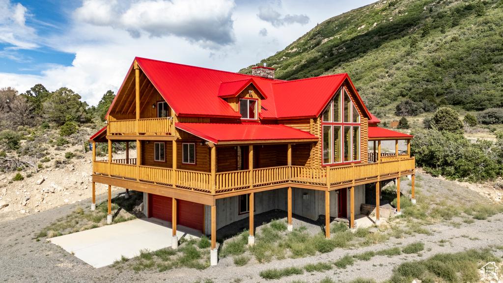Back of house with a balcony and a garage