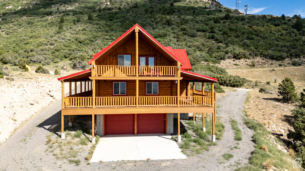 View of front of property featuring a balcony and a garage