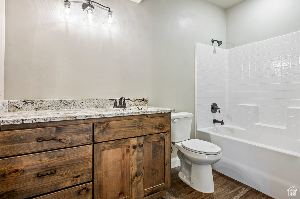 Full bathroom with shower / bath combination, toilet, vanity, and wood-type flooring