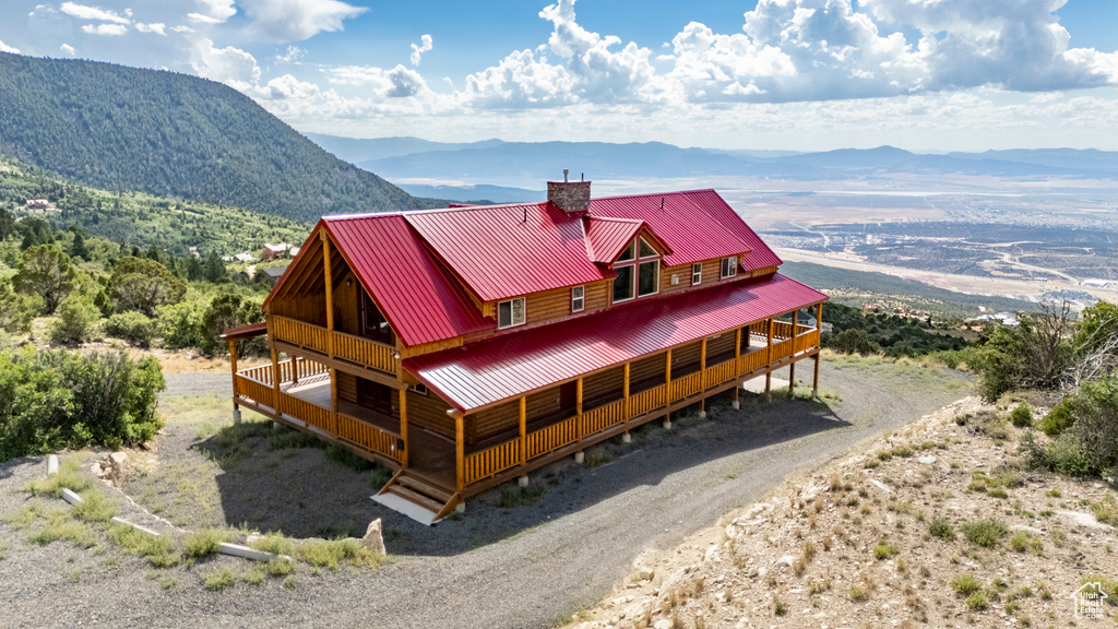 View of front of property with a deck with mountain view