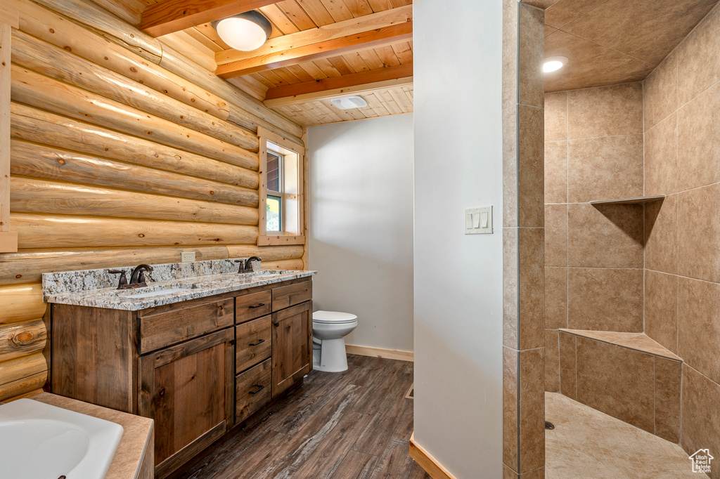 Bathroom featuring toilet, hardwood / wood-style floors, beam ceiling, wooden ceiling, and rustic walls