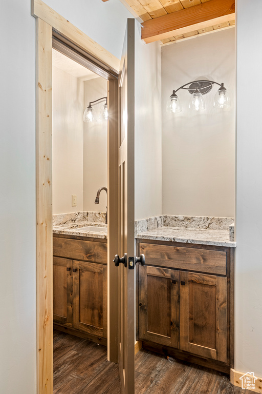 Bathroom with wood-type flooring, vanity, and beamed ceiling