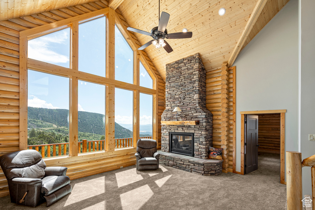 Living room with high vaulted ceiling, a fireplace, log walls, a mountain view, and wood ceiling