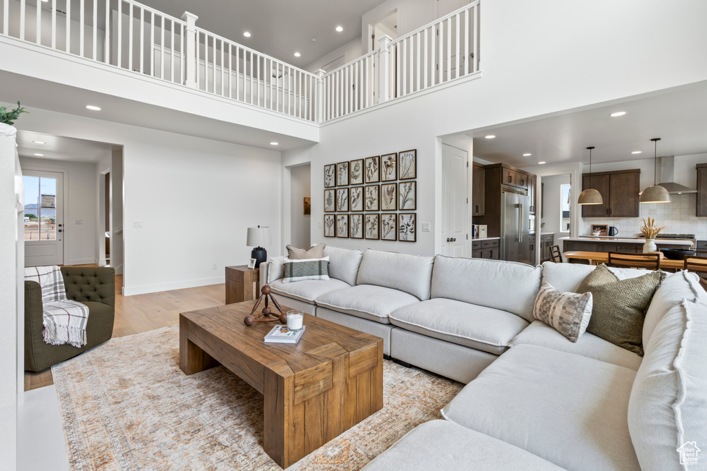 Living room with a high ceiling and light hardwood / wood-style floors