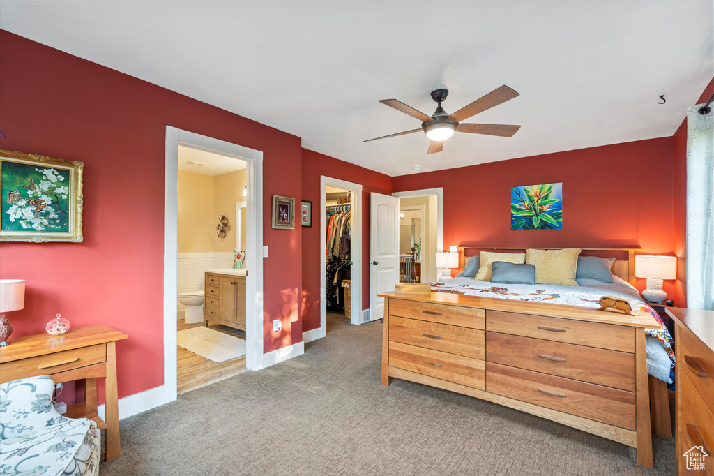 Bedroom featuring ensuite bath, dark carpet, ceiling fan, a spacious closet, and a closet