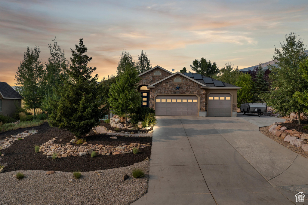 View of front facade with solar panels and a garage