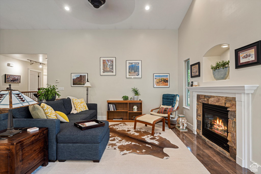 Living room featuring ceiling fan, a fireplace, and hardwood / wood-style flooring