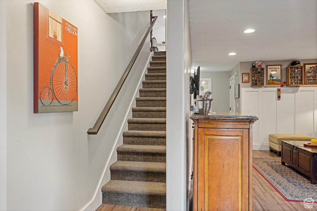 Staircase featuring hardwood / wood-style flooring