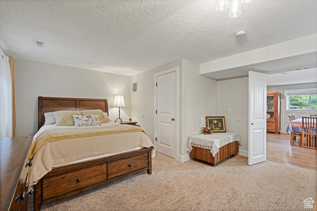 Bedroom with light wood-type flooring and a textured ceiling