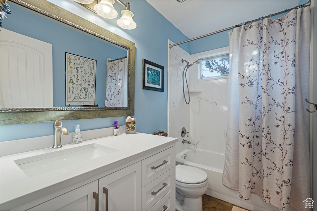 Full bathroom featuring shower / bath combo, vanity, and toilet