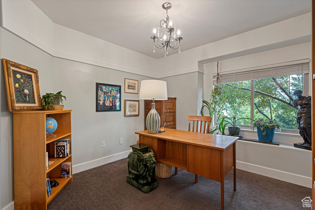 Office space with a notable chandelier and dark carpet