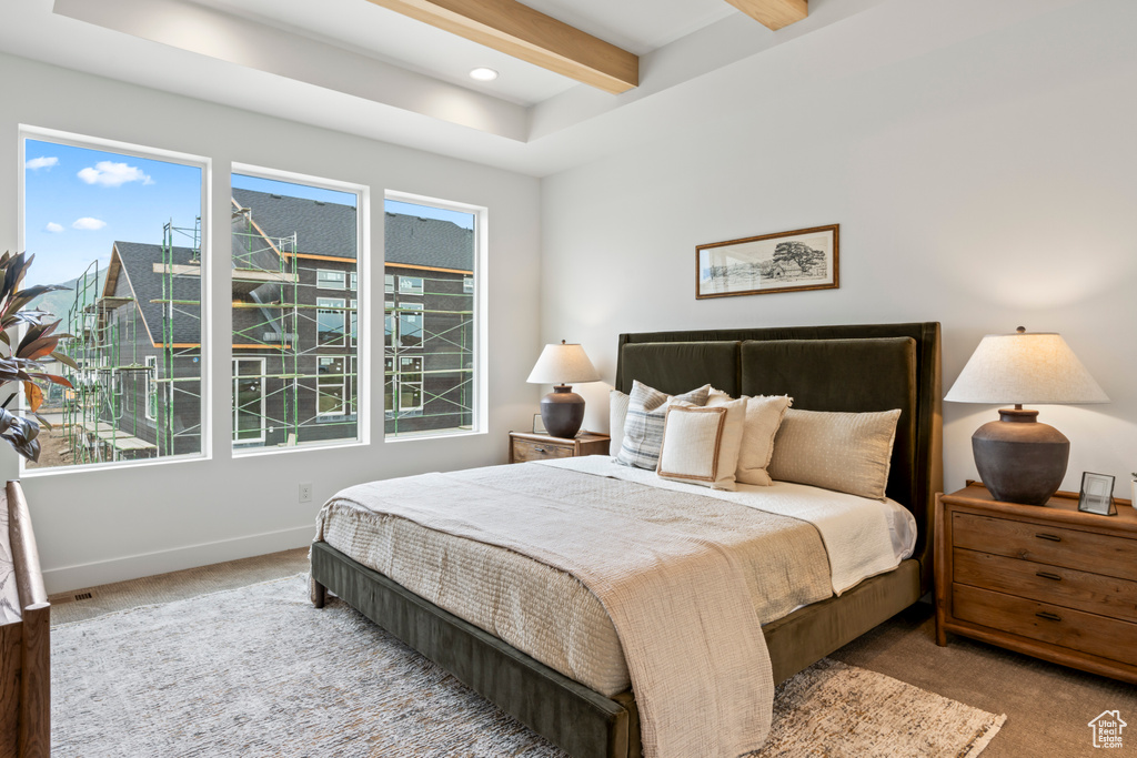 Carpeted bedroom with beam ceiling